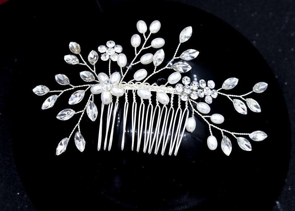 Wedding Hair Accessory in Silver. Rhinestone Crystals and Pearls are mounted on a hair comb with a display of crystals and pearls across the hair measuring 12.5cm x 6.5cm.